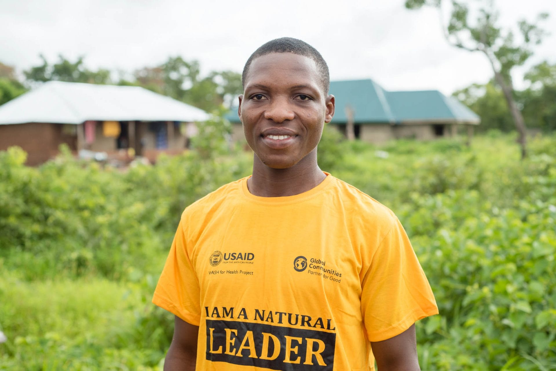 Man standing in front of houses wearing I am a natural leader shirt