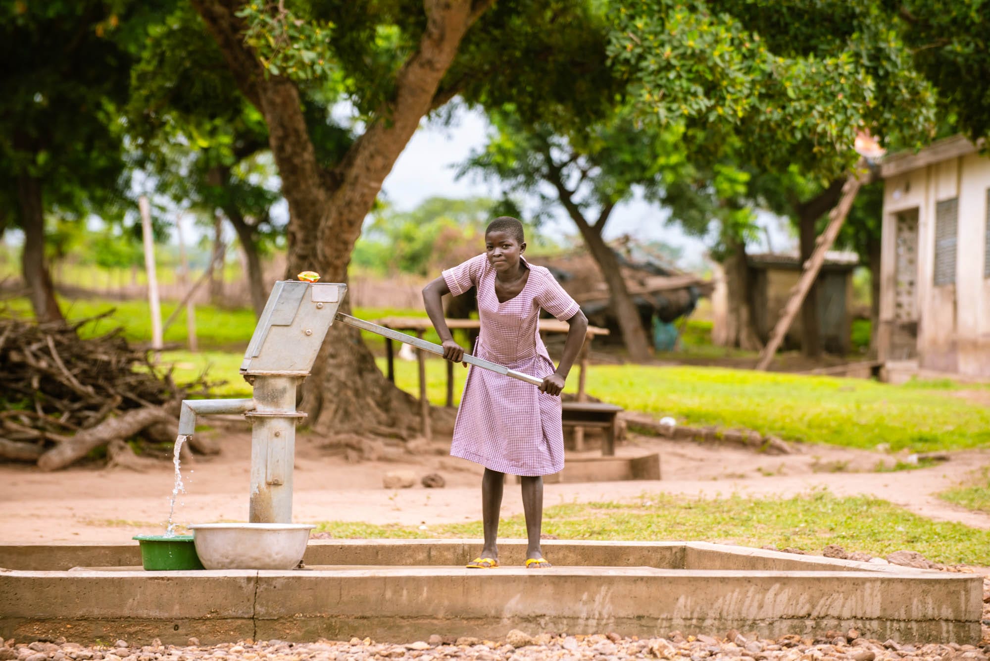 Photo of a girl pumping water.