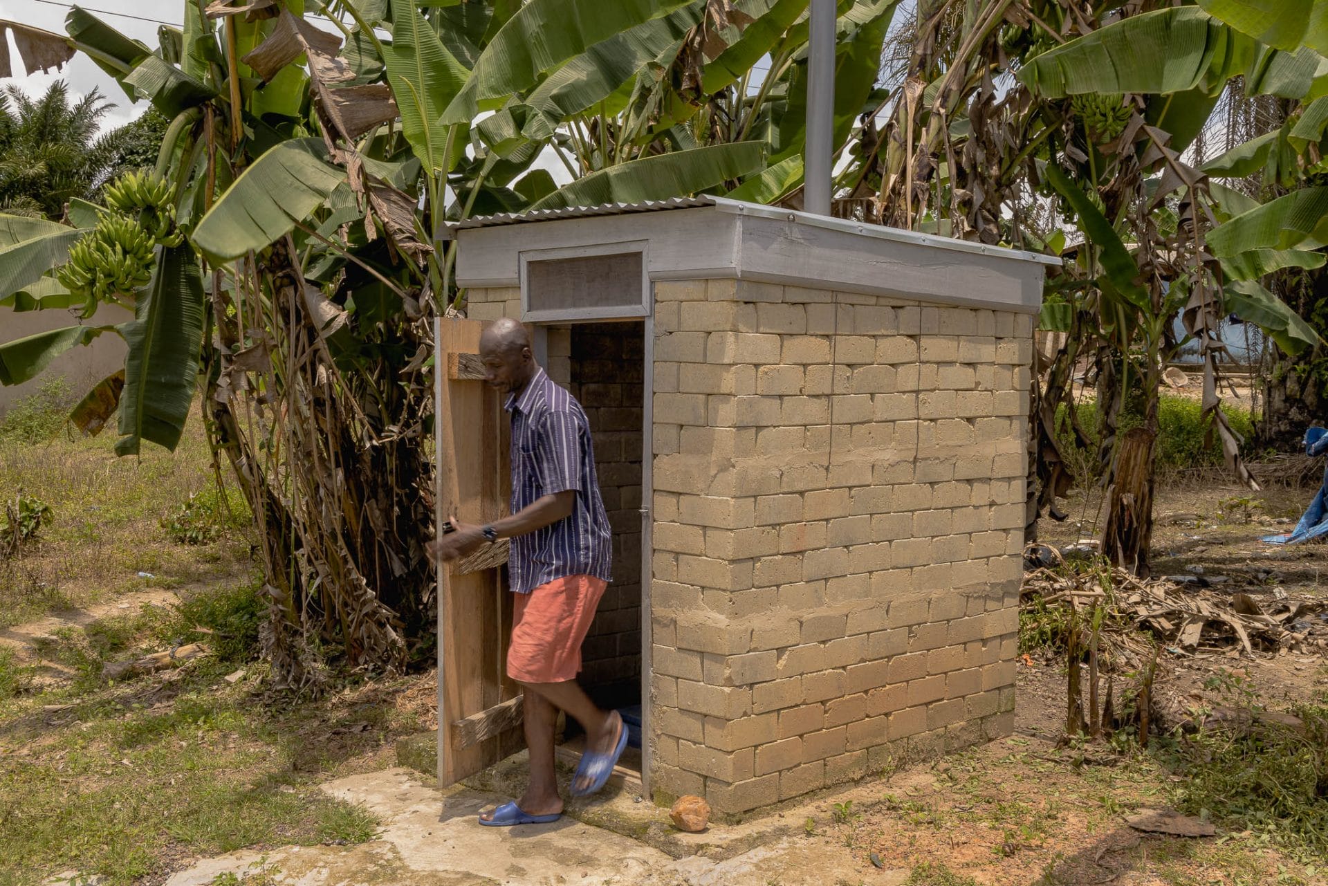 A man exiting a sanitation facillity (Digni-Loo installed washroom)